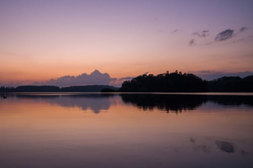 Reflet paisible au crépuscule aux gîtes de Flo, Saint Ennemond, avec lac calme et forêt en silhouette