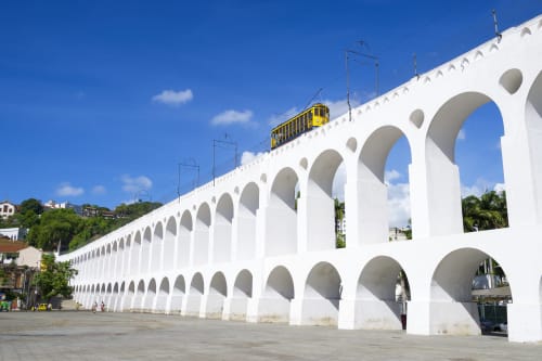 Yellow tram on historic white arched aqueduct viaduct in Rio de Janeiro near Rio Vibes Hostel
