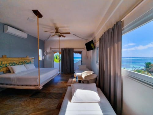 Suite de lujo frente al mar en el 40 Cañones Hotel de Mahahual con cama king, vistas al océano y amenidades modernas