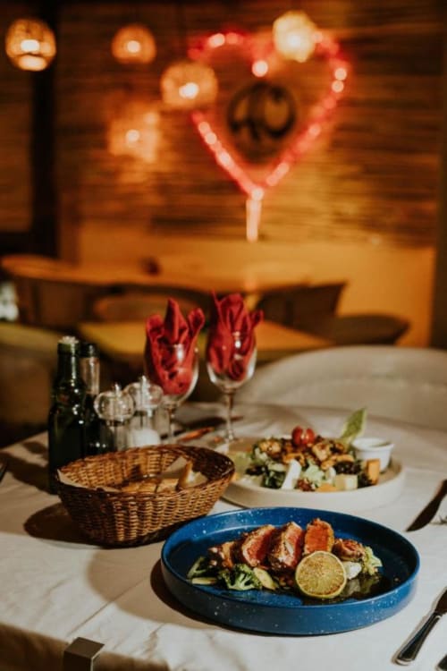 Cena elegante en el Hotel 40 Cañones Mahahual con pato presentado, vino e iluminación ambiental
