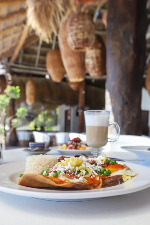Gourmet hotdog con acompañamientos y bebidas servidos en el Hotel 40 Cañones de Mahahual