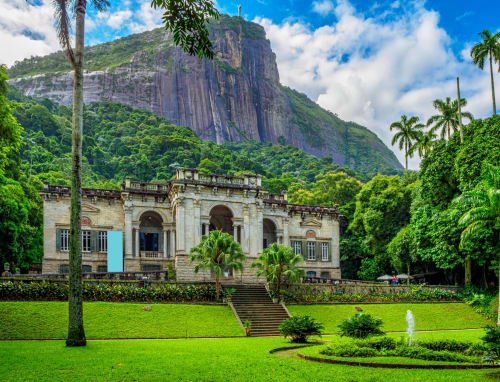 Mansão colonial histórica no Rio Vibes Hostel no Rio de Janeiro com formação rochosa imponente e jardins tropicais exuberantes