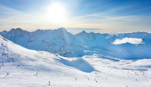 Pentes alpines enneigées avec skieurs à la station de ski de Brdes-les-Bains, pics montagneux en arrière-plan