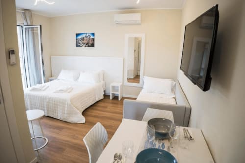 Camera moderna della Residence Balconi del Conero a Marcelli con letti gemelli, angolo cottura, TV e pavimentazione in legno