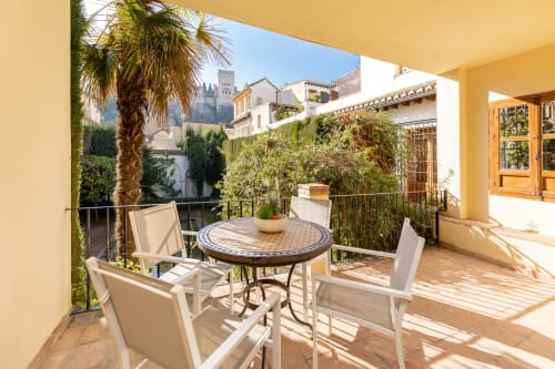 Relájate en esta acogedora terraza con vistas a la Alhambra. Un espacio perfecto para disfrutar del aire libre y la serenidad del Albaicín.