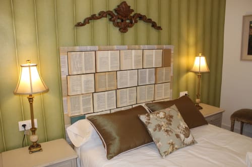 Habitación con cabecero de libros, cama con cojines florales, luz cálida y detalles clásicos en apartamento en Granada.