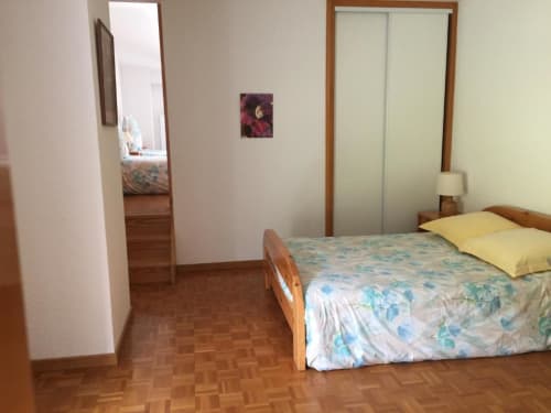 Chambre spacieuse avec lit en bois, oreillers jaunes et parquet aux Chambres d'hôtes le Grand Bienfaisy à Remiremont
