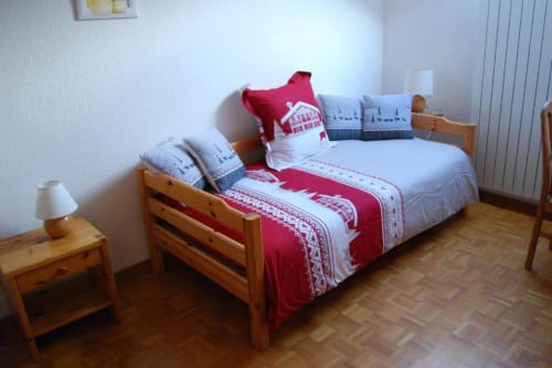 Chambre douillette avec literie rouge et blanche aux Chambres d'hôtes le Grand Bienfaisy à Remiremont, lit et table de nuit en bois