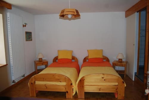 Deux lits jumeaux avec literie jaune et orange dans la chambre Red-tailed aux Chambres d'hôtes le Grand Bienfaisy, Remiremont