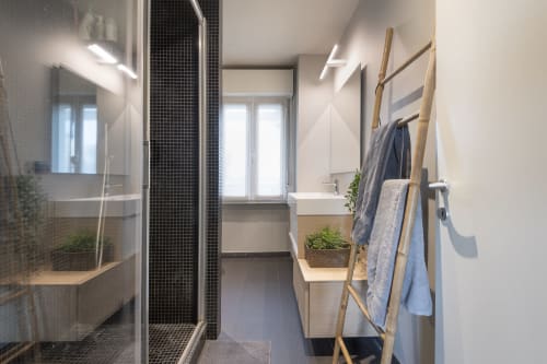 Bagno moderno presso GIRESIO 41 Milan B&B con doccia in piastrelle nere, scaletta in legno per asciugamani e luce naturale