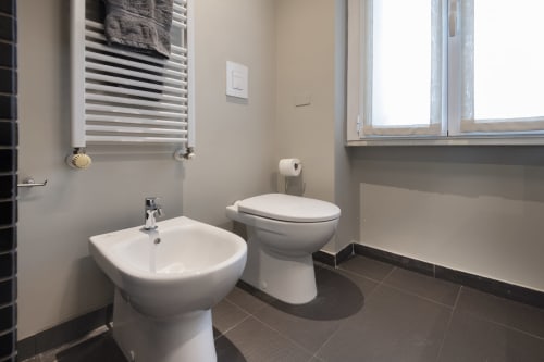 Bagno moderno della GIRESIO 41 B&B Milano con bidet, WC, lavabo, scaldasalviette e pavimenti in scuro