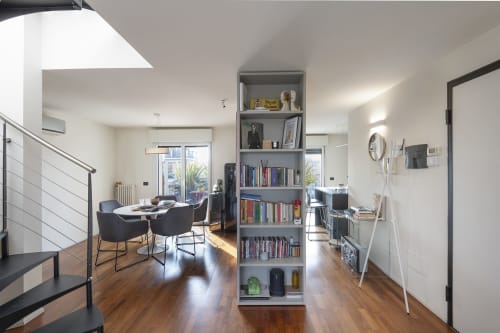 Spazioso living open-plan con pavimenti in legno, scaffali grigi, zona pranzo e design minimalista presso GIRESIO 41 Milano B&B