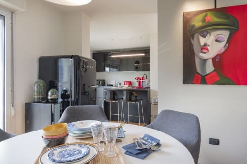 Moderna zona pranzo presso GIRESIO 41 B&B Milano con tavolo rotondo, cucina contemporanea e decorazioni pop art alle pareti