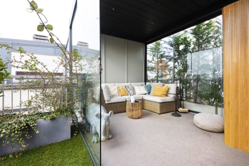 Terrazza moderna dell'hotel boutique GIRESIO 41 a Milano con sedute in rattan, cuscini gialli e piante verdi