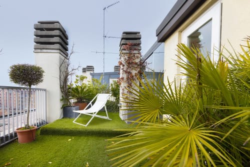 Terrazza panoramica di GIRESIO 41 boutique B&B a Milano con sdraio bianca, piante di palma e vista sulla città