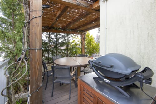 GIRESIO 41 Terrazza milanese con pergolato, tavolo da pranzo, barbecue e albero rampicante d'edera