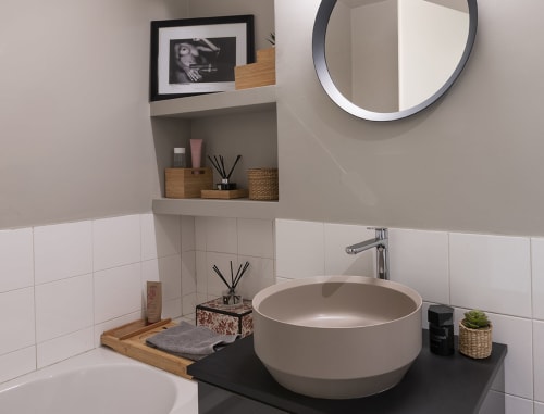 Bagno moderno GIRESIO 41 Milano con lavabo tondo, piastrelle bianche, specchio circolare e design minimalista