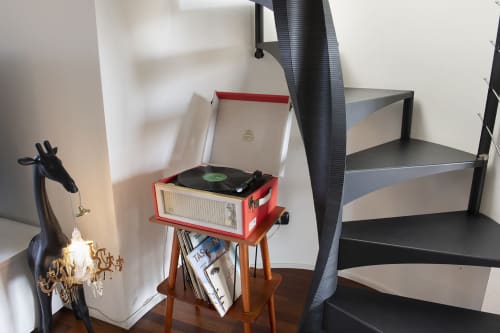 Giradischi vintage rosso su supporto in legno presso la boutique hotel GIRESIO 41 di Milano, con oggetti decorativi e scaffalature