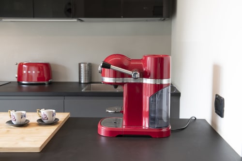 Cucina moderna a GIRESIO 41 Milano B&B con caffettiera rossa, tostapane e tazzine da espresso su piano nero