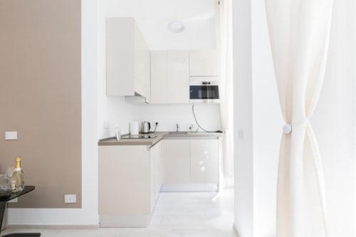 Moderne weiße Küche mit Edelstahlgeräten in der Magnolia Apartments Mailand Zimmer 18A, mit kompaktem Layout und
