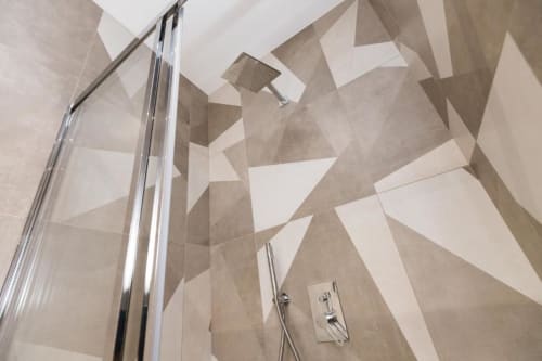 Modern geflieste geometrische Dusche in der Magnolia Apartments Milan mit Chrombeschlägen und Regenduschkopf