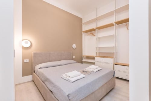 Modernes Schlafzimmer im Magnolia Apartments Milan mit Queensize-Bett, Holzregalen und weißen Lagerelementen