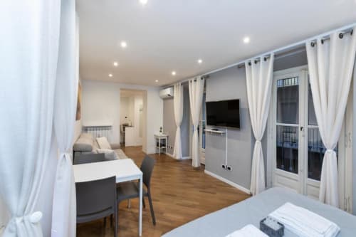 Современная студия в апартаментах Magnolia Apartments Milan с паркетом, кухней, столовой зоной, диваном-кроватью и видом на город
