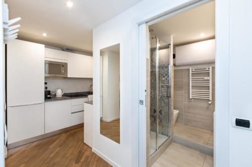 Moderne Küche und Badezimmer in den Magnolia Apartments Mailand mit weißen Möbeln, Holzböden und zeitgenössischem Design