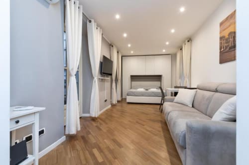 Modernes Apartment in Magnolia Apartments Mailand mit Sofa, Bett, Küchenzeile, Holzboden und Stadtblick