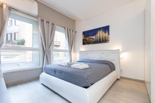 Modernes Schlafzimmer in den Magnolia Apartments Mailand mit Queensize-Bett, Stadtblick und Kunstwerk des Mailänder Doms