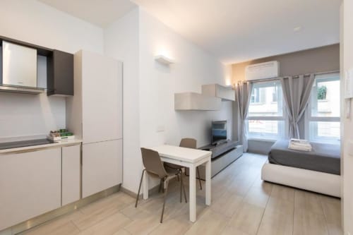 Modernes Studio in den Magnolia Apartments Mailand mit Kochnische, Essbereich, Bett und Stadtblick