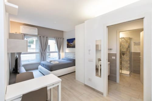 Современная студия-спальня в Magnolia Apartments Milan с кроватью, письменным столом и собственной ванной