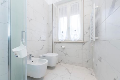 Modernes weißes Marmorbadezimmer in den Magnolia Apartments Mailand mit Bidet, Toilette und Spiegelschrank