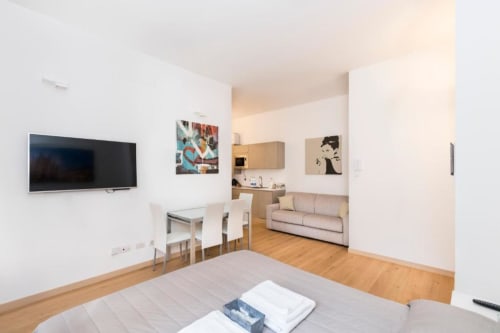 Modernes Studio-Apartment in Magnolia Apartments Mailand mit Bett, Küchenzeile, Essbereich, Sofa und Flachbild-TV