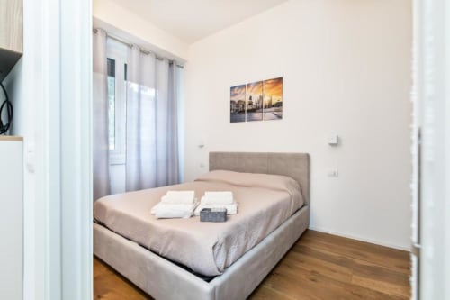 Modernes Schlafzimmer in Magnolia Apartments Milan mit Queensize-Bett, Parkettboden und Gartenblick-Kunstwerk