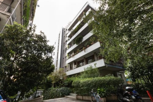 Modernes Wohngebäude in Mailand mit begrünten Balkonen, üppiger Gartenanlage und zeitgenössischer Architektur