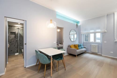 Modernes Mailänder Apartment mit Esstisch, Sofa, Pendelleuchten und Duschbad in den Magnolia Apartments