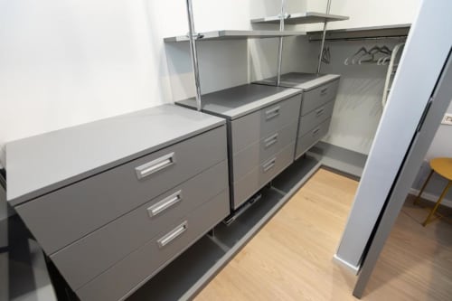 Modernes graues Küchenmöbel mit Schubladen und Regalen in den Magnolia Apartments Mailand, Holzfußboden sichtbar