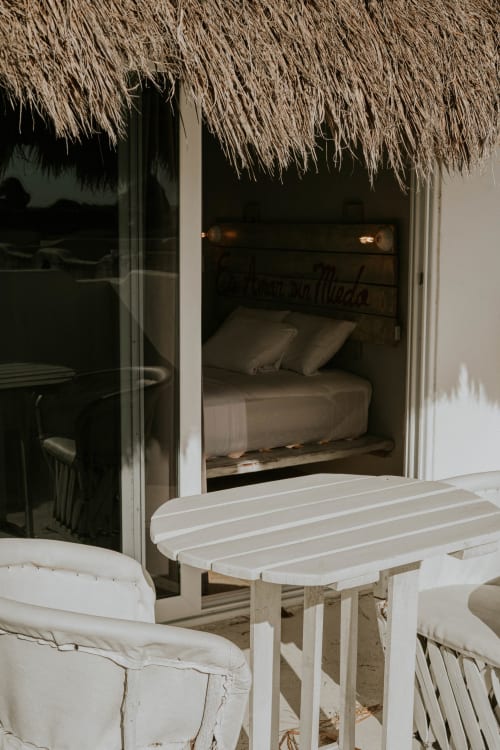 Habitación frente al mar en Hotel 40 Cañones, Mahahual, con techo de palapa, acceso por puertas de vidrio y terraza blanca