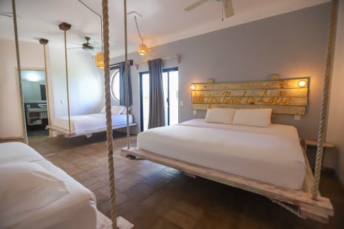 Habitación espaciosa en 40 Cañones, Mahahual, con camas suspendidas por cuerdas, sábanas blancas e iluminación cálida