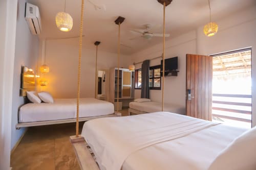 Habitación moderna del Hotel 40 Cañones en Mahahual con cama columpio, lámparas colgantes y vista al patio