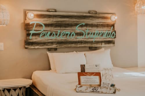 Habitación del Hotel 40 Cañones en Mahahual con cabecera de madera y ropa de cama blanca