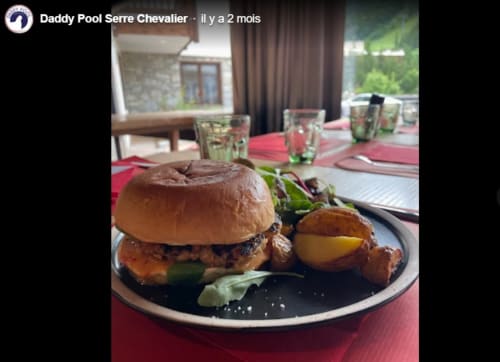 Burger gourmet e patate arrosto serviti nella sala da pranzo del Serre Chevalier Cristal Lodge con vista sulle montagne
