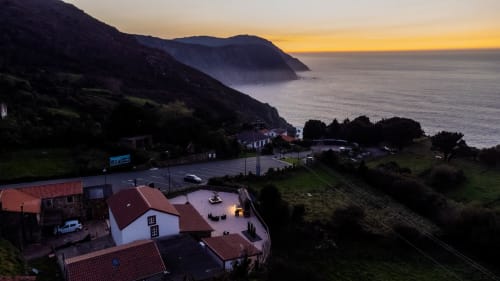 Casa Rural San Andrés de Teixido al atardecer, con vistas a la costa gallega entre montañas y océano