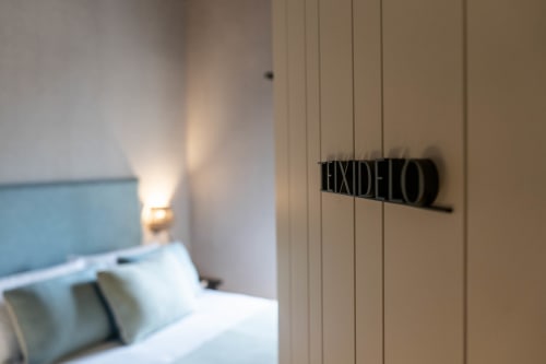 Letrero de puerta de habitación en Casa Rural San Andres de Teixido con cama visible en el interior, Teixido, A Coruña