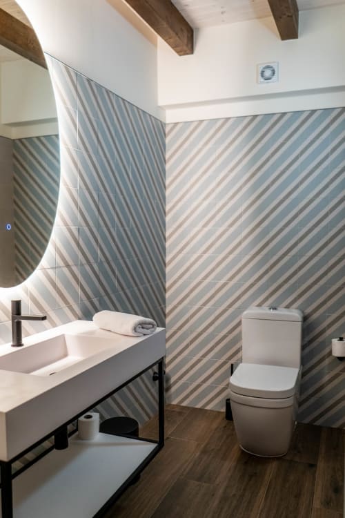 Baño moderno en Casa Rural San Andres de Teixido con paredes de azulejos rayados, lavamanos blanco e inodoro