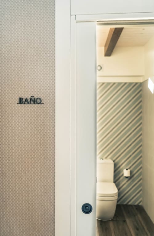 Baño de Casa Rural San Andres de Teixido con pared de azulejos rayados y moderno inodoro blanco