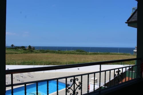 Vista desde el balcón de Apartamentos Los Gemelos con vistas a la piscina, playa y océano Atlántico en Foz, Galicia