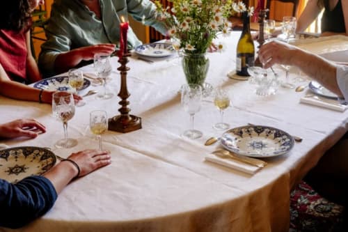 Élégant dressage de table raffiné au Château de Vaux Morvan avec assiettes décorées, verres à vin et fleurs fraîches