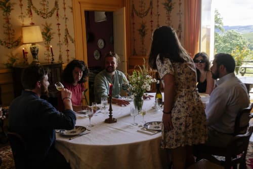 Des clients dînent ensemble au Château de Vaux Morvan, un élégant gîte français à Étang sur Arroux avec décor d'époque